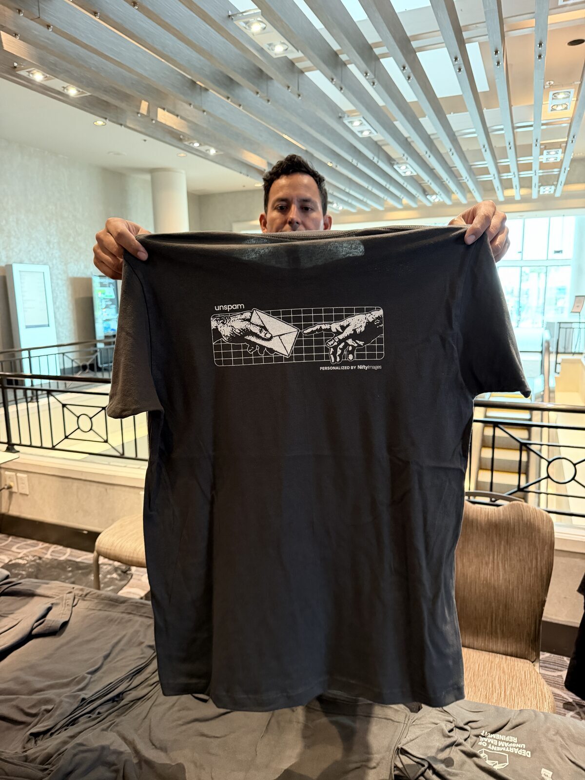 A guest holding up a freshly printed tee